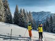 Sehbehinderte Skiläuferin mit ihrer Begleitsportlerin bei einer Verschnaufpause auf der Piste