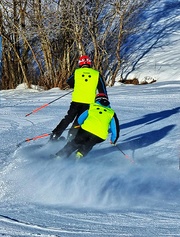 Blinde Skiläufern fährt hinter ihrem Guide die Piste runter