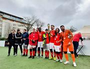 Die Spielerinnen, Spieler und Betreuerteam stehen in einer Stirnreihe. Kapitänin Sulyok stemmt den Pokal in die Höhe.