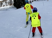 blindes Kind fährt auf Ski hinter ihrem Begleitsportler her