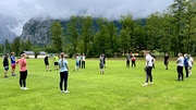 Eine Gruppe Blindensportler mit Begleitsportlern und Übungsleiter bei einem Orientierungsspiel am Rasenfeld