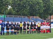 Auf dem Spielfeld: Argentinien links aufgestellt und Österreich rechts aufgestellt, in der Mitte die Schiedsrichter