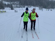 Parallel läuft ein junger, blinder Langläufer an der Seite seiner Begleitsportlerin